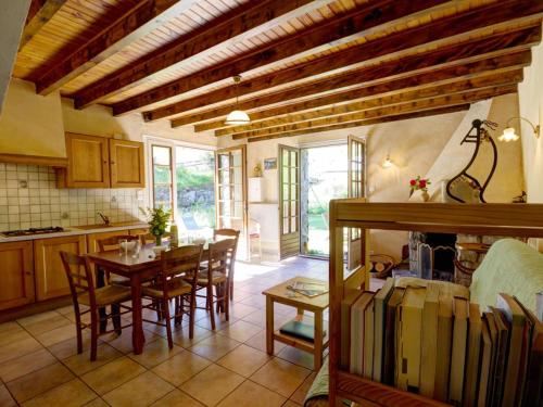 une cuisine et une salle à manger avec une table et des chaises dans l'établissement Gîte et studio avec cheminée, terrasse, salle de jeux et nature préservée à La Versanne - FR-1-496-280, à La Versanne