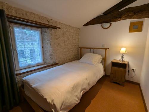 a bedroom with a large bed and a window at Gîte spacieux avec piscine chauffée, jardin, WIFI et animaux admis - FR-1-653-273 in Angeduc