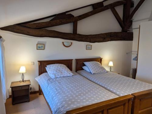 a bedroom with a bed with a blue comforter at Gîte spacieux avec piscine chauffée, jardin, WIFI et animaux admis - FR-1-653-273 in Angeduc