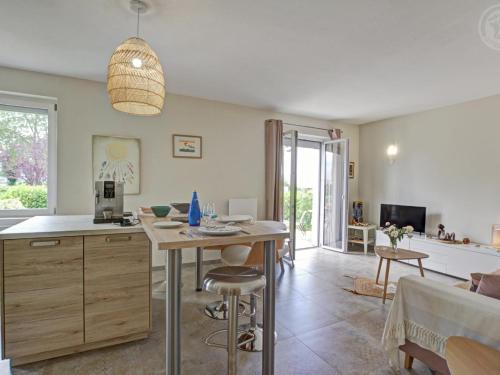une cuisine et un salon avec une table et un canapé dans l'établissement Charmant gîte moderne avec cour privée, tout équipé, parking sécurisé, au cœur du Roannais - FR-1-496-316, à Riorges
