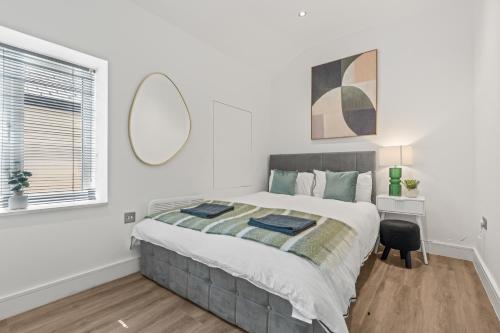 a bedroom with a large bed and a desk at Central Luxe Flats With Spa Facilities in Cardiff