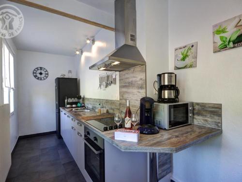 - une cuisine avec un comptoir et une cuisinière four supérieur dans l'établissement Gîte familial avec cheminée, terrasse et jardin - Animaux acceptés - FR-1-496-177, à Arcon