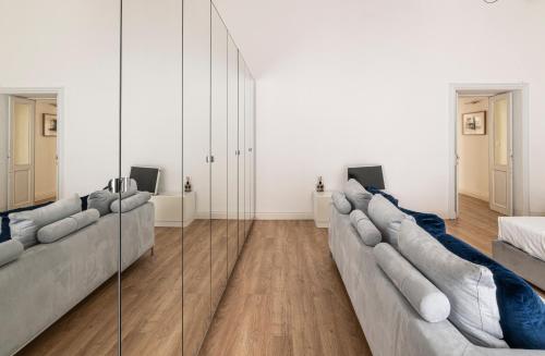 a living room with a long couch and a mirror at La Dépendance Hotel in Noto