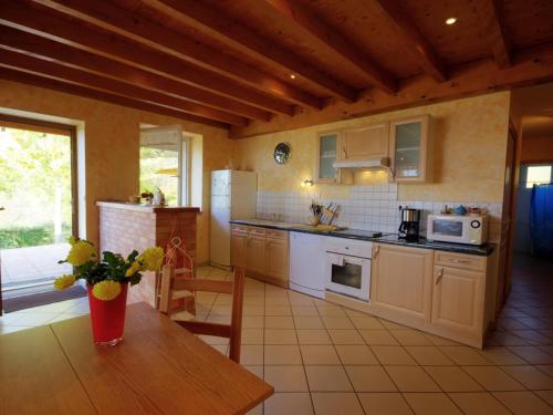 - une cuisine avec des appareils blancs et une table en bois dans l'établissement Gîte rural 2 chambres avec jardin, terrasse, wifi, animaux acceptés - FR-1-496-130, à Saint-Héand