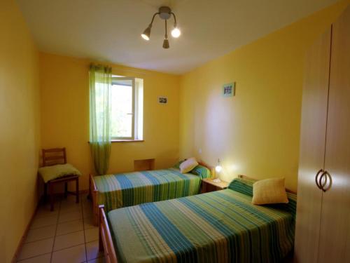 two beds in a room with yellow walls at Gîte campagne proche St-Étienne, animaux admis - FR-1-496-130 in Saint-Héand