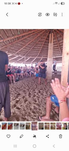 a group of people sitting in the sand at a beach at Maison Kmar in Awlād ‘Umar