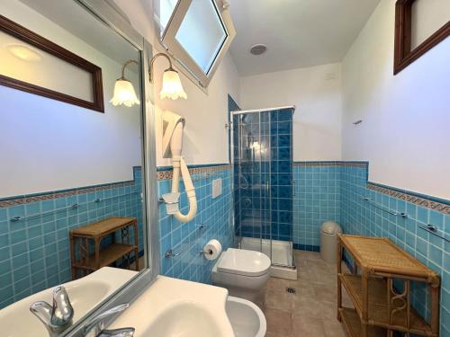 a bathroom with a toilet and a sink and a shower at Appartamenti Casa Rossi in Capoliveri