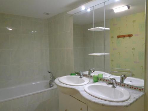 bagno con 2 lavandini, vasca e specchio di Gîte spacieux avec cheminée et WiFi - Animaux admis - FR-1-496-87 a Saint-Paul-de-Vézelin