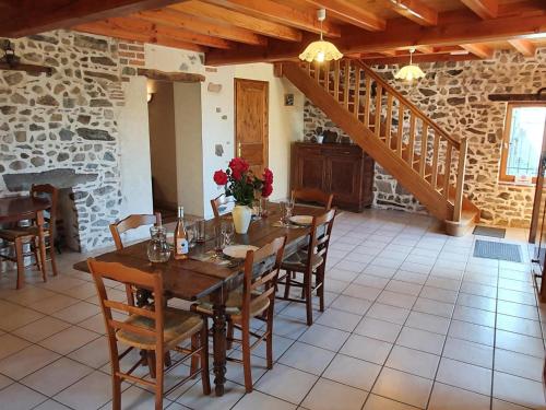 une salle à manger avec une table et des chaises en bois dans l'établissement Gîte spacieux avec cheminée et WiFi - Animaux admis - FR-1-496-87, à Saint-Paul-de-Vézelin