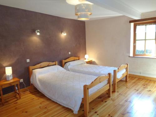 two beds in a bedroom with two lamps and a window at Gîte spacieux à Renaison avec cheminée, jardin et équipements enfants - FR-1-496-257 in Renaison