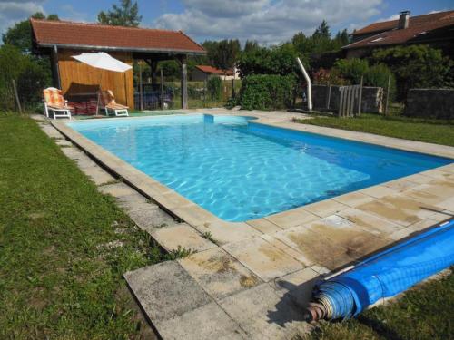 une grande piscine bleue dans une cour dans l'établissement Gîte spacieux à Renaison avec cheminée, jardin et équipements enfants - FR-1-496-257, à Renaison