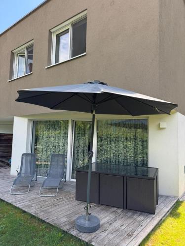 a large black umbrella sitting on a patio at Apartment Elena in Hinterstoder
