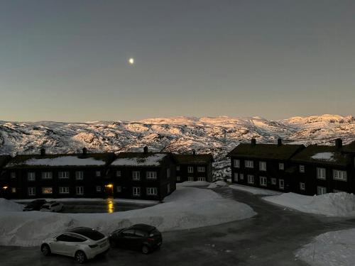 un gruppo di edifici con montagne innevate sullo sfondo di Family-Friendly Mountain Cabin In Haukeli a Vågsli
