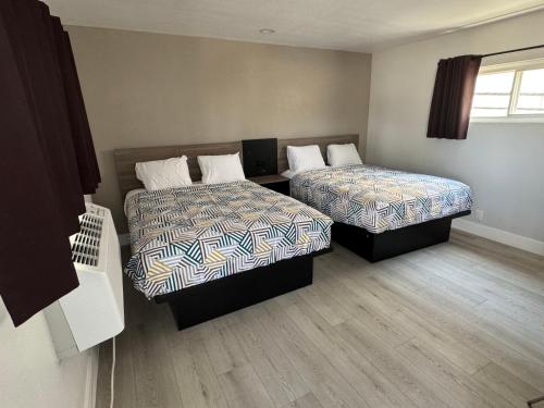 a hotel room with two beds and a window at Keystone Motel in Norwalk