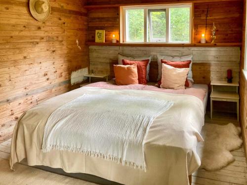 a bedroom with a large bed in a wooden room at Off-Grid Cabin In Your Private Swedish Forest in Simlångsdalen