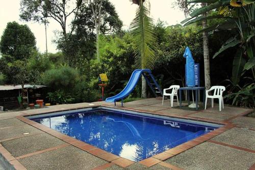 a small swimming pool with a slide and a playground at Ecohotel Villa Natalia in Boquía