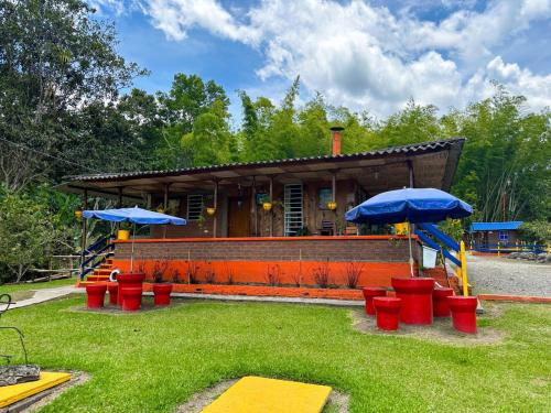 a building with red and blue umbrellas in front of it at Ecohotel Villa Natalia in Boquía