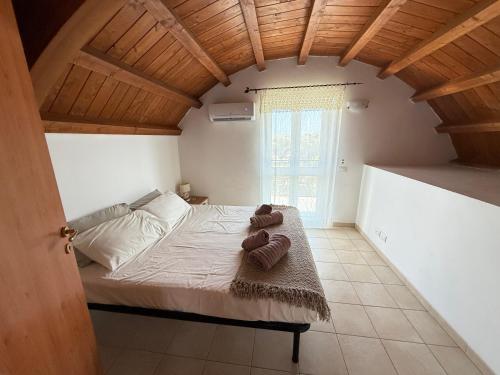a bedroom with a bed with a wooden ceiling at South Italy summer house in Stazione di San Sostene