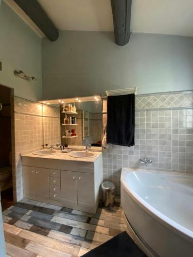 a bathroom with two sinks and a tub and a mirror at Provencal Villa With Panoramic Views In Luberon in Apt