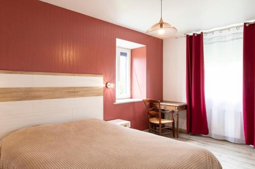 a bedroom with a bed and a desk and a window at Gîte Jean Montet, piscine chauffée partagée, Wifi, salle de jeux, animaux de la ferme in Beynat