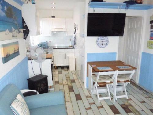 ein Wohnzimmer mit Tisch und Küche in der Unterkunft ElE G Holiday let's Bridlington in Bridlington