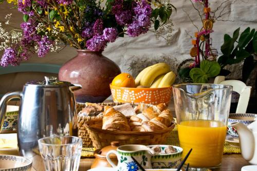 Una mesa con una cesta de pan y zumo de naranja. en Chambres de la Ville d'Ys, en Cléden-Cap-Sizun