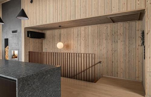 a kitchen with a counter and a wooden wall at Architect Designed Mountain Cabin At Kvitfjell in Favang