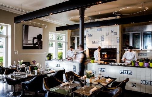 ガルドーネ・リヴィエラにあるHotel Bella Rivaのテーブルとシェフがキッチンに並ぶレストラン