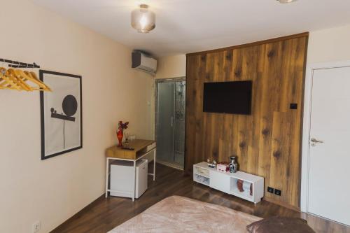 a living room with a tv on a wooden wall at Stupa Guesthouse in Prizren