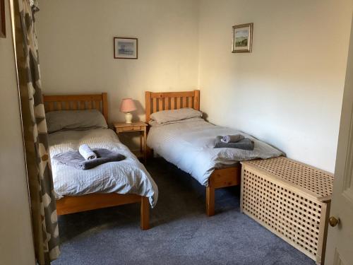 two beds in a room with towels on them at Large farmhouse in Snowdonia, North Wales in Talsarnau