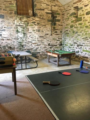 a room with two tables and a ping pong table at Large farmhouse in Snowdonia, North Wales in Talsarnau