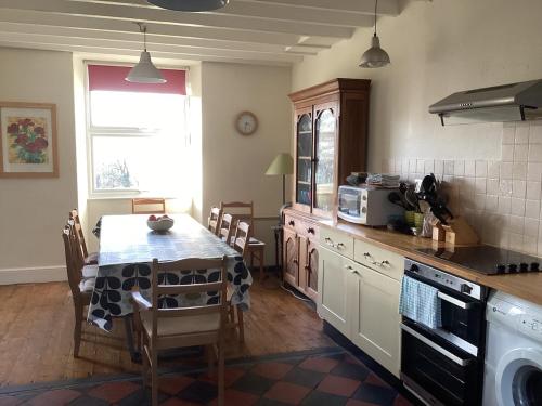 a kitchen with a table and a dining room at Large farmhouse in Snowdonia, North Wales in Talsarnau