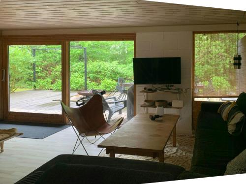 Una sala de estar con un sofá, una mesa y un televisor. en Nature Plot With Stream By Lohals Beach, en Tranekær