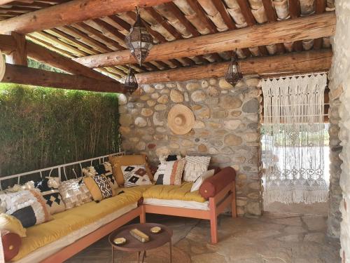 a living room with a couch in a stone wall at La Bastide des Cyprès - La Parenthèse in Les Mées