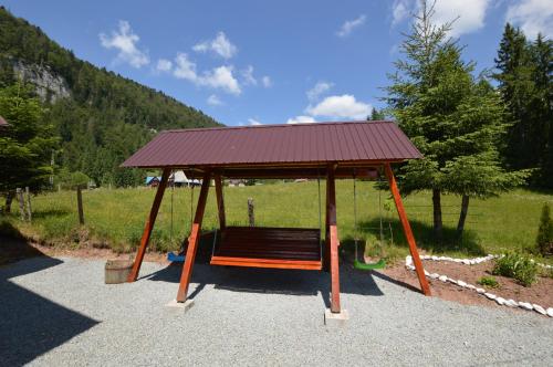 a park bench with a roof on top of it at Casa de Piatră - Colț de Rai in Arieşeni