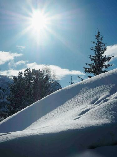 a snow covered hill with the sun in the sky at Stylish Cabin In Scenic Surroundings in Skare