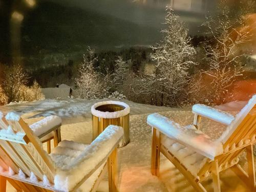 two chairs sitting in the snow on a patio at Stylish Cabin In Scenic Surroundings in Skare