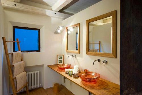 ドルチェアックアにあるStone Farmhouses Among Olives And Vinesの洗面台と2つの鏡があるバスルーム