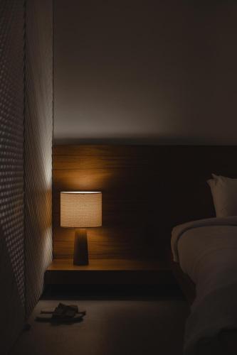 a lamp in the corner of a bedroom with a bed at Conforto e Vista Panorâmica com Banheira Hotel Vision TV WiFi Ar Cond e Cozinha in Brasilia