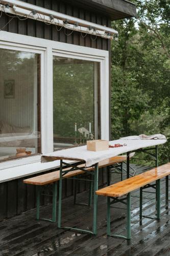 a table and two benches on the porch of a house at Adorable Retro Home With Lovely Terrace in Bryrup