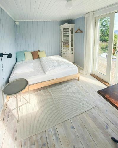 a bedroom with a bed and a table and a window at Romantic Country Cabin With Fjord Views On Åmøy in Stavanger