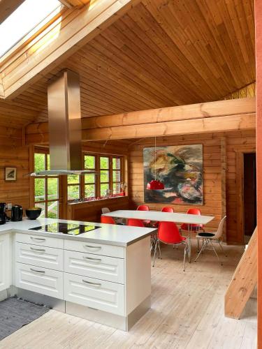 a kitchen with a table and red chairs in a room at Wooden House With Nature Views Near Silkeborg in Silkeborg