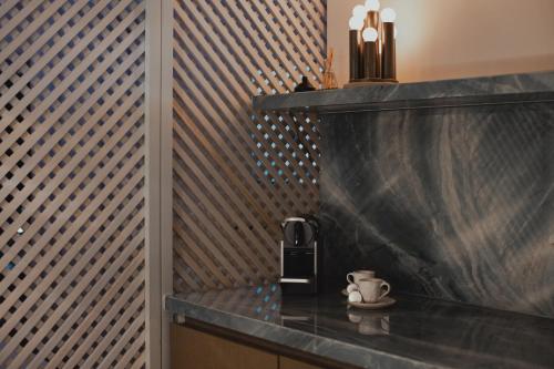 a counter with a coffee maker and a cup on it at Conforto e Vista Panorâmica com Banheira Hotel Vision TV WiFi Ar Cond e Cozinha in Brasilia