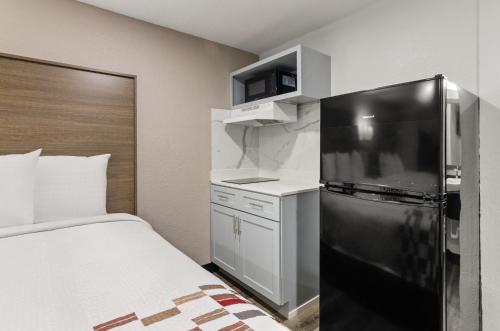 a kitchen with a refrigerator and a bed in a room at Red Roof Inn Wytheville in Wytheville