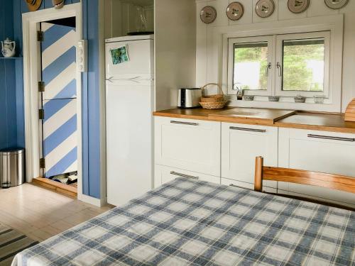 a kitchen with white cabinets and a blue at Family Cabin By The Sea With Private Pier in Ula