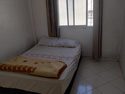 Una cama pequeña en una habitación con ventana. en Tranquil Rental Rooms in Agadir, en Agadir