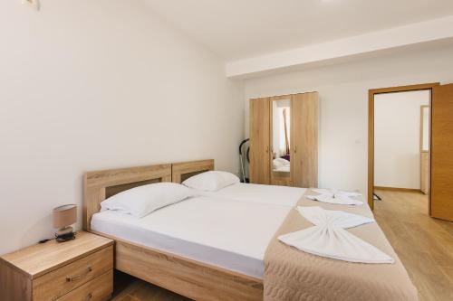 a bedroom with a large bed with white sheets at Chez Vous in Ulcinj