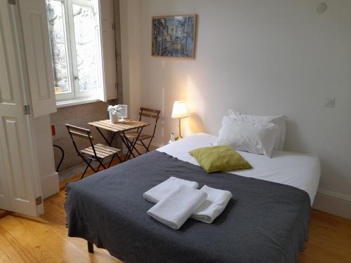 een slaapkamer met een groot bed met handdoeken erop bij Great&Cosy São Bento in Porto