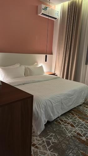 a bedroom with a large bed with white sheets at شقق دخول ذاتي in Taif