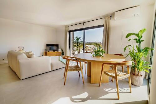 een woonkamer met een tafel en een bank bij Ocean Breeze Retreat near Ericeira in Carvoeira